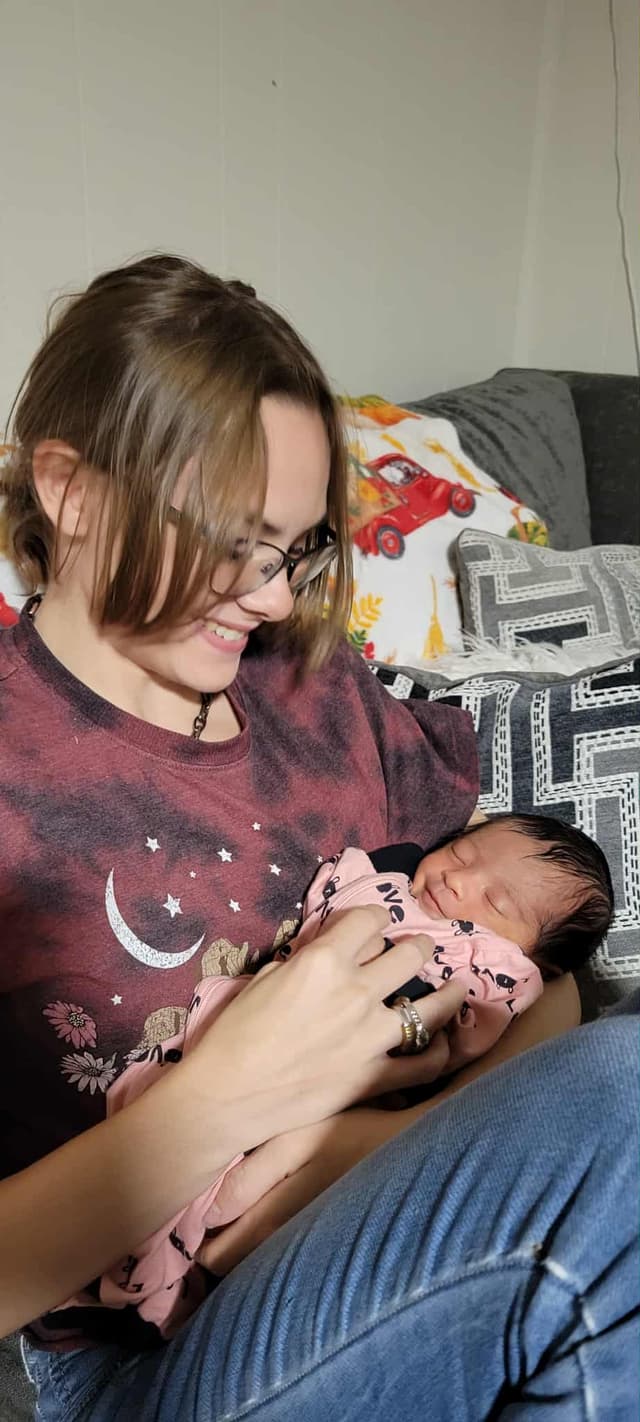 Megan gently holding a newborn